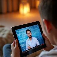 Person watching a video lecture on a tablet in a comfortable setting